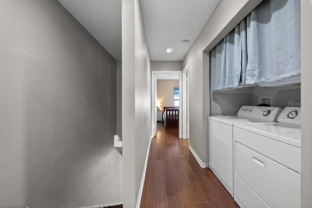 laundry room with a textured ceiling, cabinets, dark hardwood / wood-style floors, and washing machine and clothes dryer