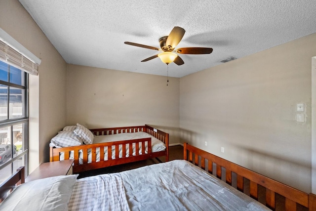 bedroom with ceiling fan and a textured ceiling