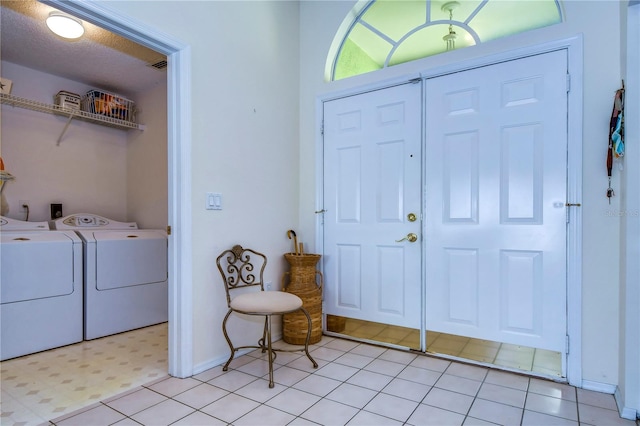 foyer entrance featuring light tile flooring and washing machine and clothes dryer