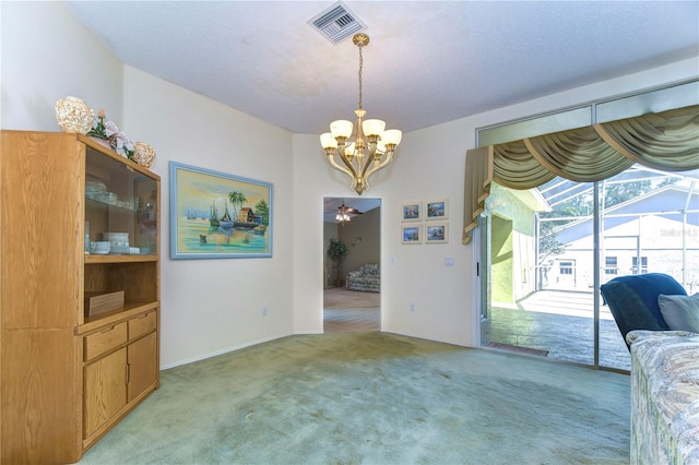 carpeted living room featuring ceiling fan with notable chandelier and a textured ceiling