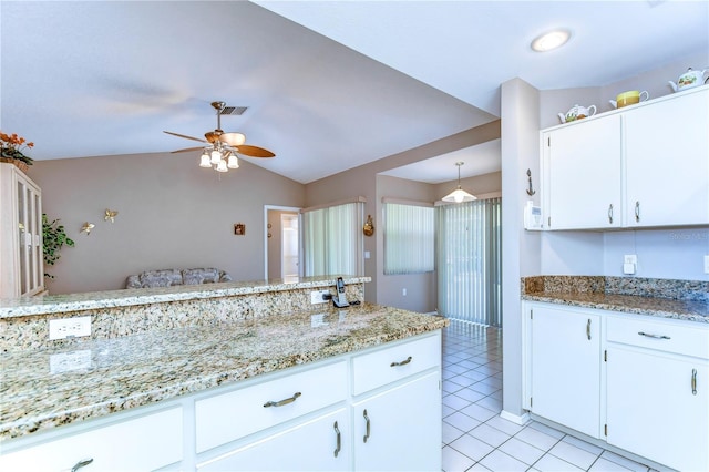 kitchen featuring light stone countertops, ceiling fan, lofted ceiling, white cabinets, and light tile floors