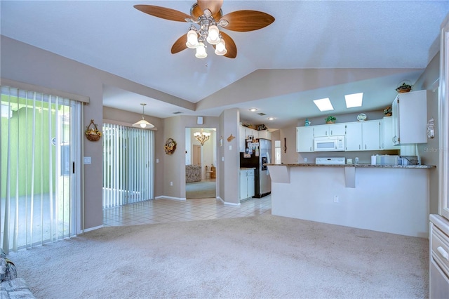 interior space with vaulted ceiling, ceiling fan, and light tile floors