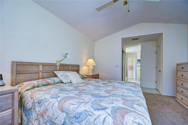 carpeted bedroom featuring lofted ceiling, ceiling fan, and a textured ceiling