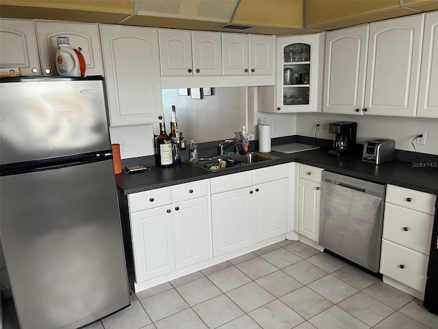 kitchen featuring white cabinetry, sink, light tile flooring, and stainless steel appliances