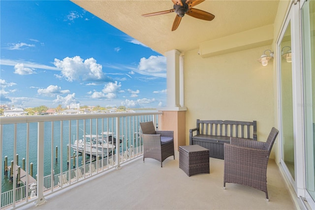 balcony featuring ceiling fan and a water view