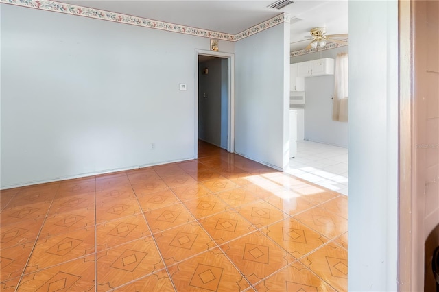 empty room with light tile patterned flooring and ceiling fan