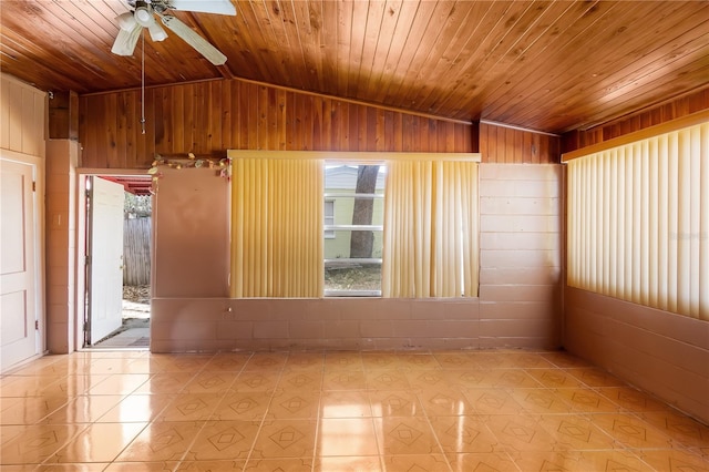 tiled spare room with lofted ceiling, wood walls, and wooden ceiling