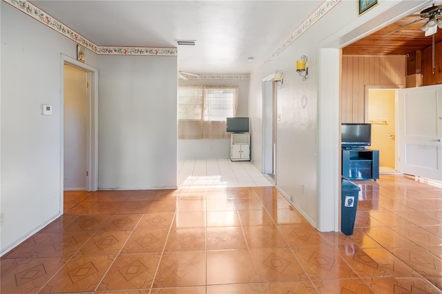 corridor featuring wooden walls and light tile patterned floors