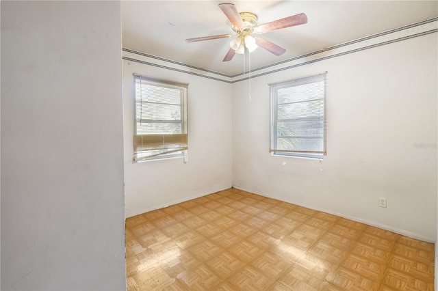 spare room featuring light parquet floors, a healthy amount of sunlight, and ceiling fan