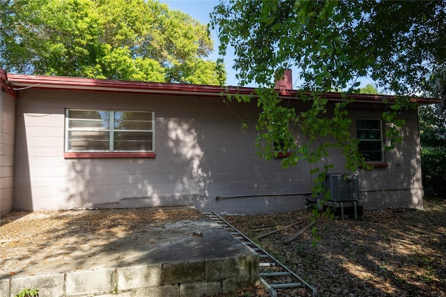 view of side of property with cooling unit and a patio area