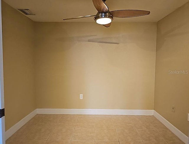 empty room with ceiling fan and light tile flooring