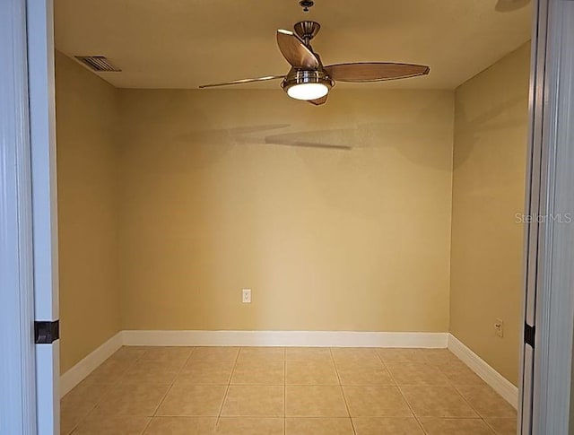 tiled spare room with ceiling fan