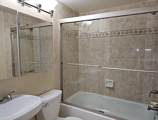 full bathroom featuring enclosed tub / shower combo, toilet, and sink