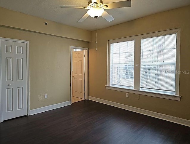 unfurnished room featuring ceiling fan and dark wood-type flooring