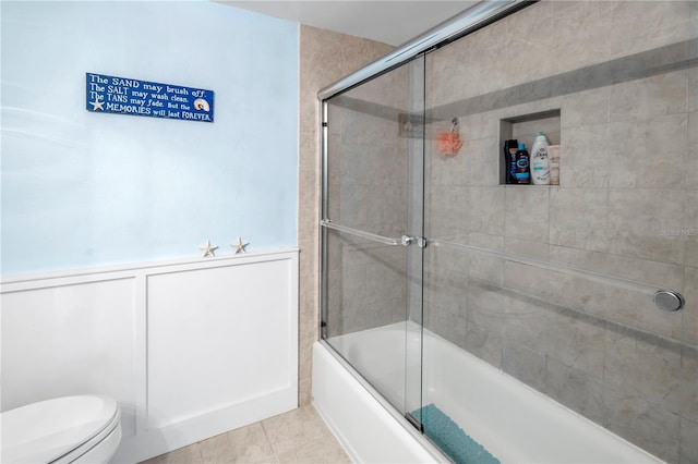 bathroom with toilet, enclosed tub / shower combo, and tile patterned flooring