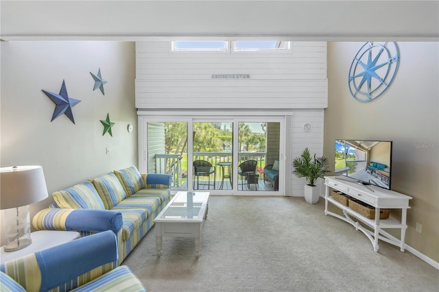 living room with a towering ceiling and carpet flooring