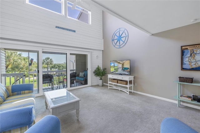 carpeted living room featuring high vaulted ceiling