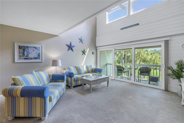 carpeted living room with a towering ceiling