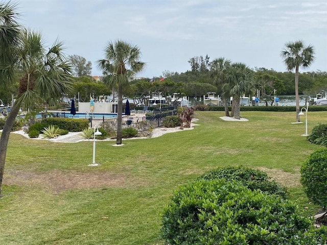 view of home's community featuring a pool and a yard