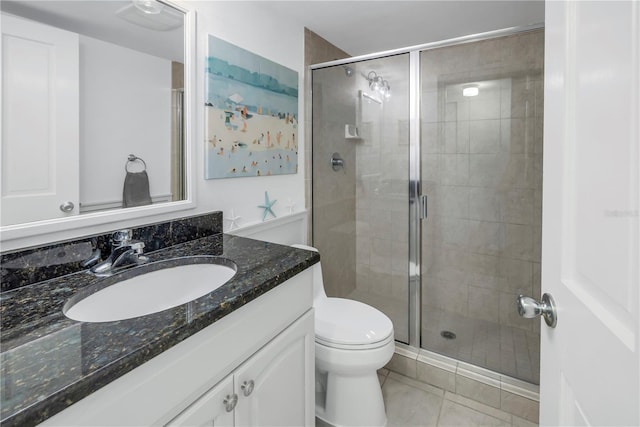 bathroom featuring an enclosed shower, vanity, tile patterned flooring, and toilet