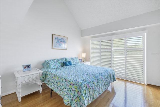 bedroom featuring hardwood / wood-style flooring and vaulted ceiling