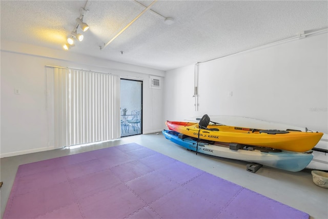 interior space featuring rail lighting and a textured ceiling