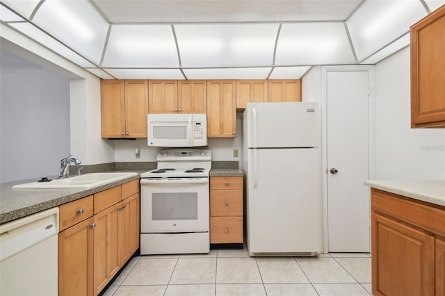 kitchen featuring white appliances, sink, and light tile floors