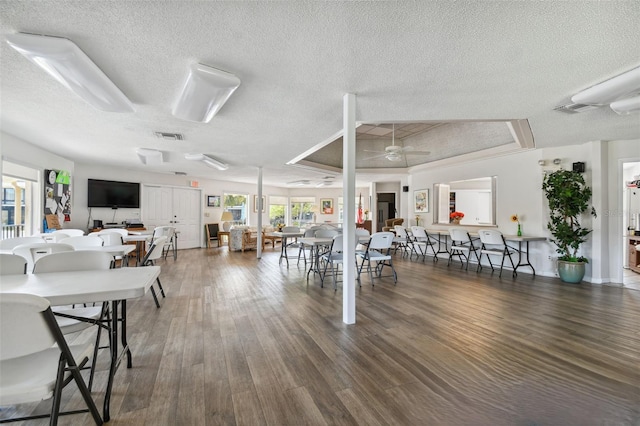 interior space featuring ceiling fan, dark hardwood / wood-style floors, a textured ceiling, and a tray ceiling