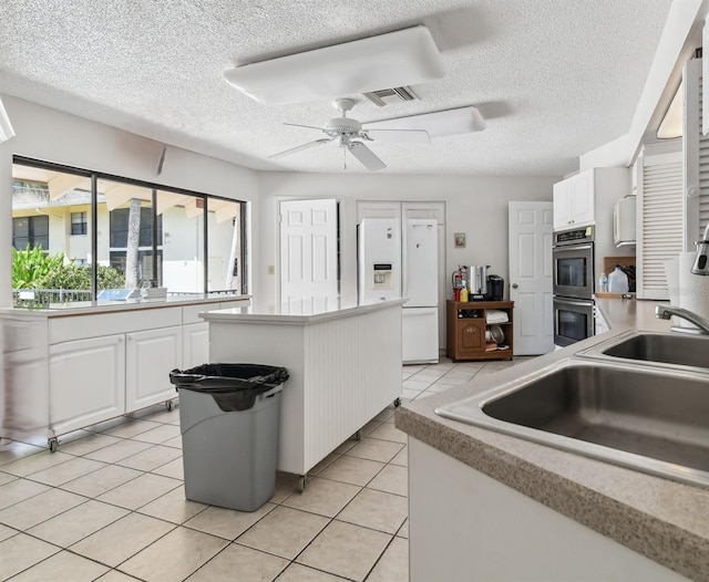 kitchen featuring white cabinetry, ceiling fan, light tile flooring, stainless steel double oven, and white refrigerator with ice dispenser