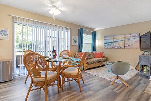 dining space with hardwood / wood-style floors and ceiling fan