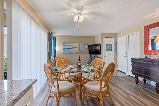 dining room featuring a textured ceiling, hardwood / wood-style floors, and ceiling fan