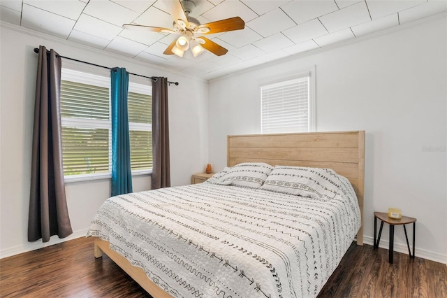 bedroom with ornamental molding, dark hardwood / wood-style flooring, and ceiling fan