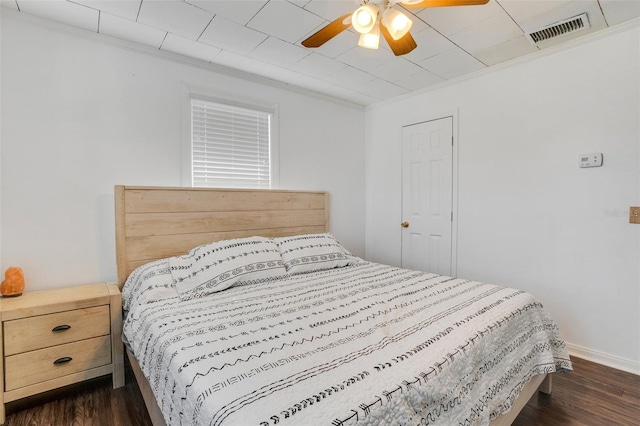 bedroom with ornamental molding, dark hardwood / wood-style flooring, and ceiling fan