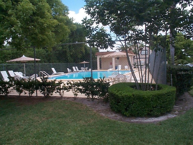 view of pool with a yard