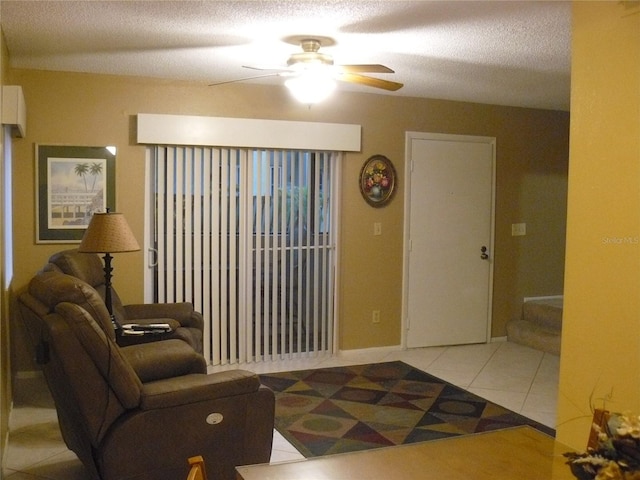 tiled living room featuring ceiling fan and a textured ceiling