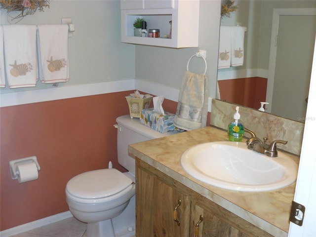 bathroom with tile patterned flooring, vanity, and toilet