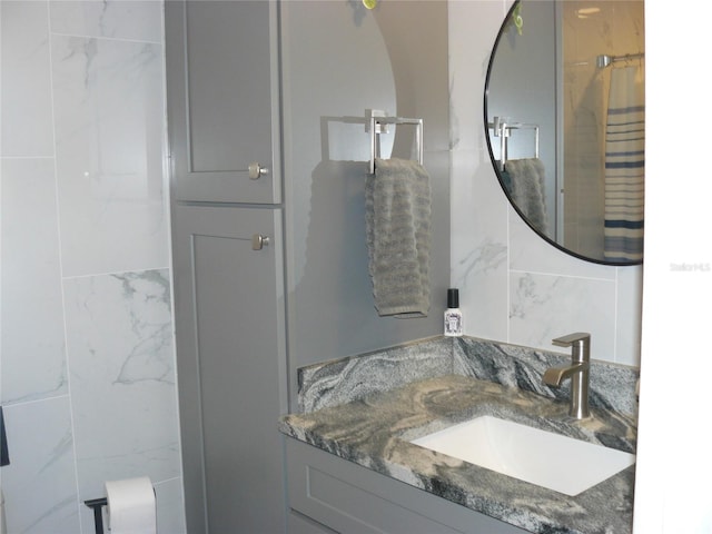 bathroom with vanity and tile walls