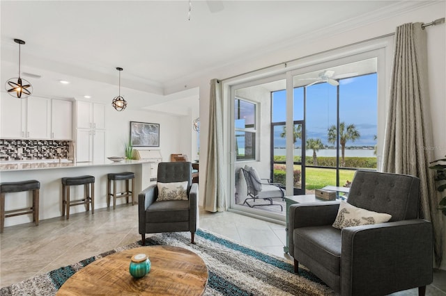 living area featuring ornamental molding, a water view, light tile patterned flooring, and ceiling fan