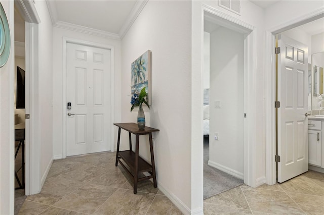 hallway featuring visible vents, baseboards, and crown molding