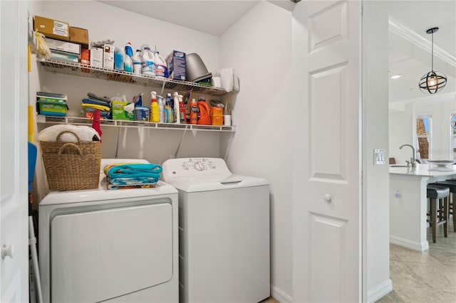 washroom with tile patterned flooring, baseboards, washer and clothes dryer, laundry area, and a sink