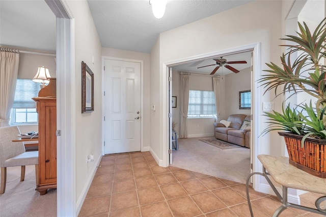 tiled entryway featuring ceiling fan and a textured ceiling