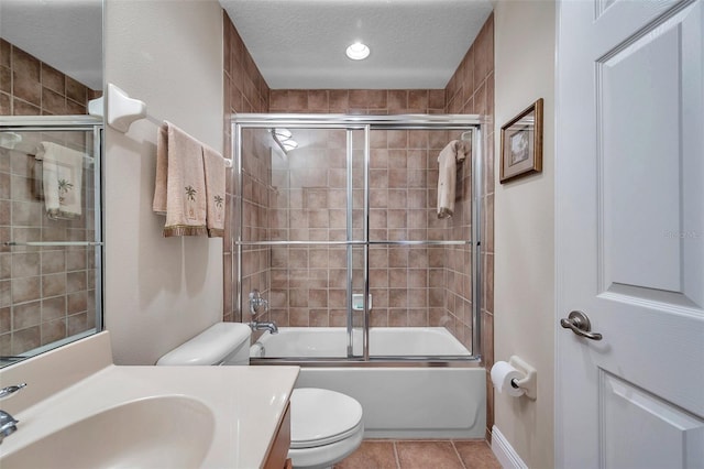 full bathroom featuring tile flooring, large vanity, a textured ceiling, combined bath / shower with glass door, and toilet