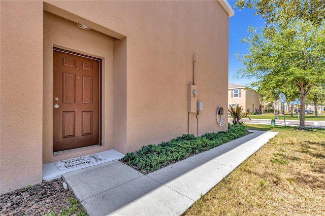 doorway to property with a lawn