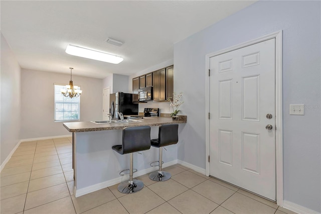 kitchen with a kitchen breakfast bar, refrigerator with ice dispenser, kitchen peninsula, and light tile floors