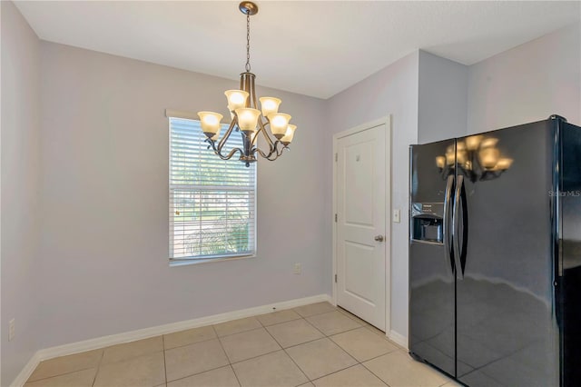 unfurnished dining area with a chandelier and light tile floors