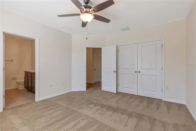 unfurnished bedroom featuring light colored carpet, ceiling fan, connected bathroom, and a closet