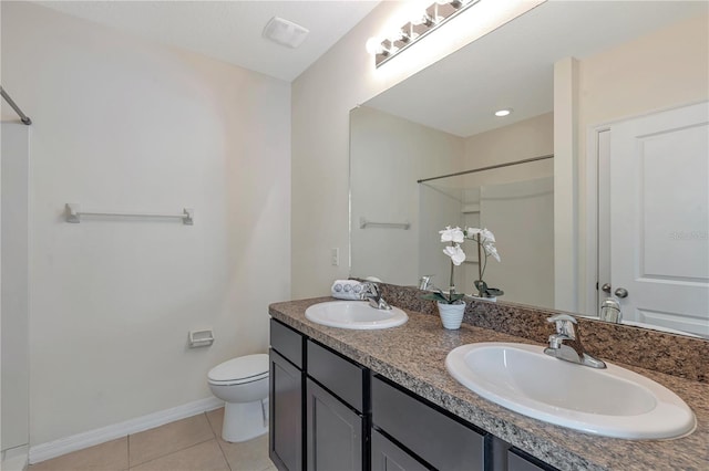 bathroom featuring tile floors, toilet, and dual vanity