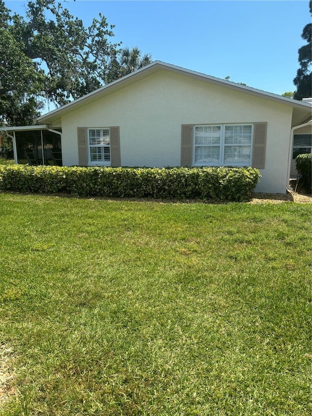 view of property exterior featuring stucco siding and a lawn