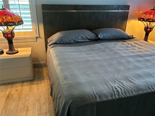 bedroom featuring wood finished floors and baseboards