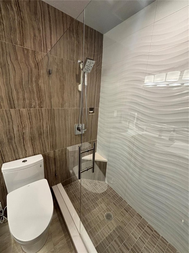 full bath featuring toilet and tiled shower